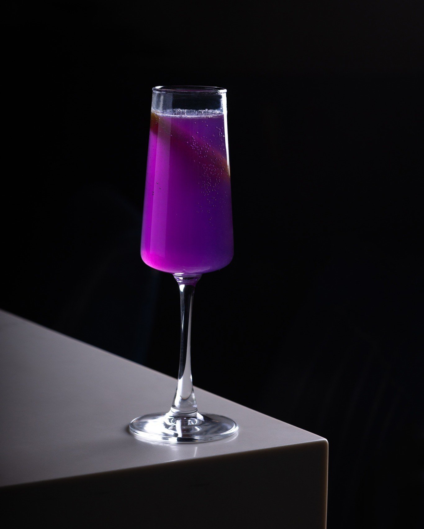 You know how some drinks look amazing but taste like disappointment? The Royal Flute is the opposite. It comes out deep blue-purple because of the butterfly pea flower, and the second citrus hits it, the whole thing shifts to pink right in front of y