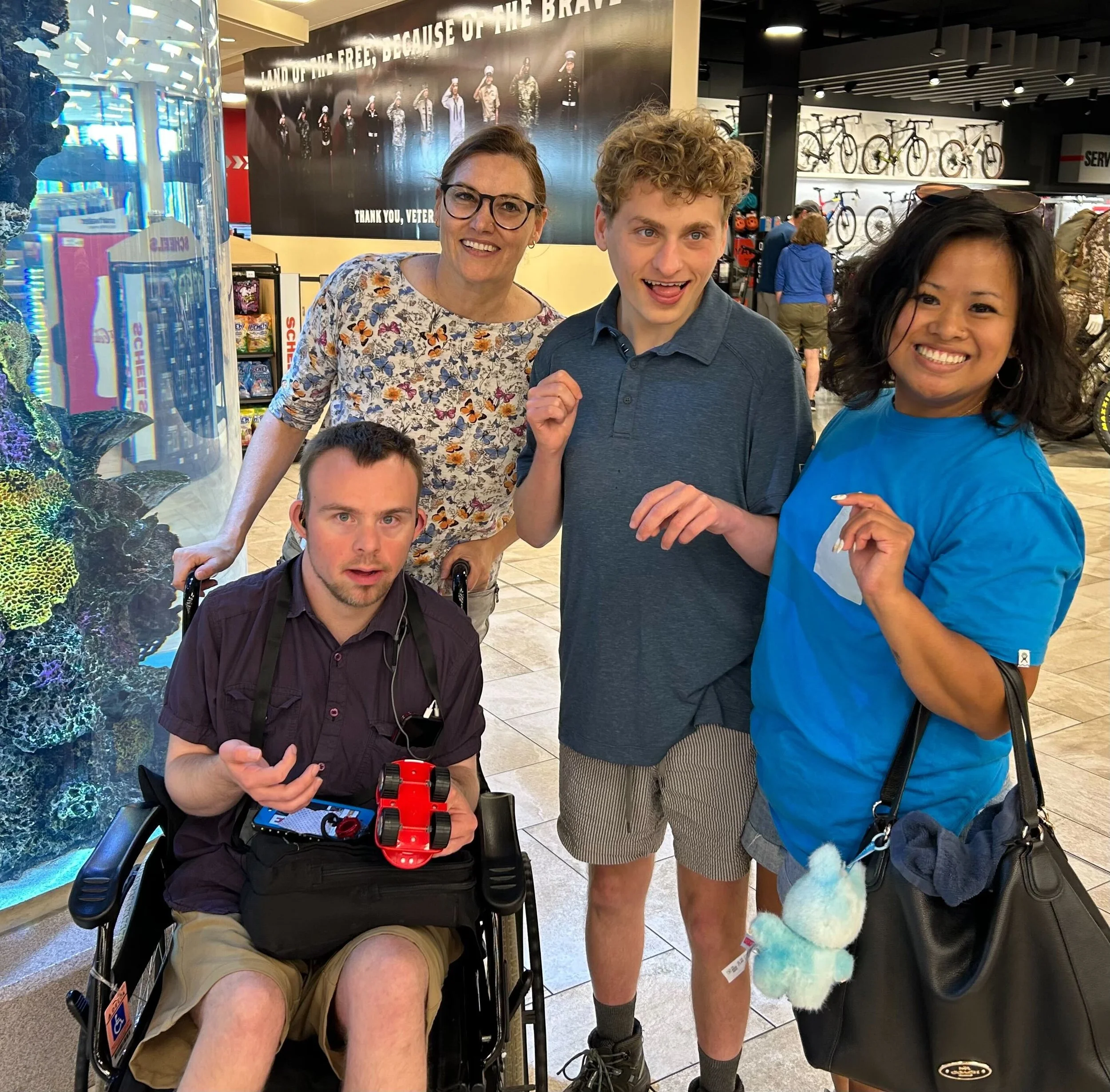 Individuals next to a fish tank smiling.