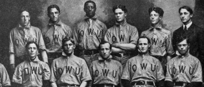 Black and white photo of nine young men in matching sports uniforms with 'OWU' on their shirts, posed in two rows for a team portrait.