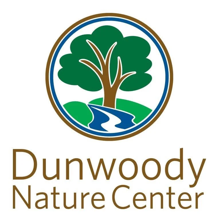 Logo of Dunwoody Nature Center featuring a tree with green leaves next to a stream within a circular border.
