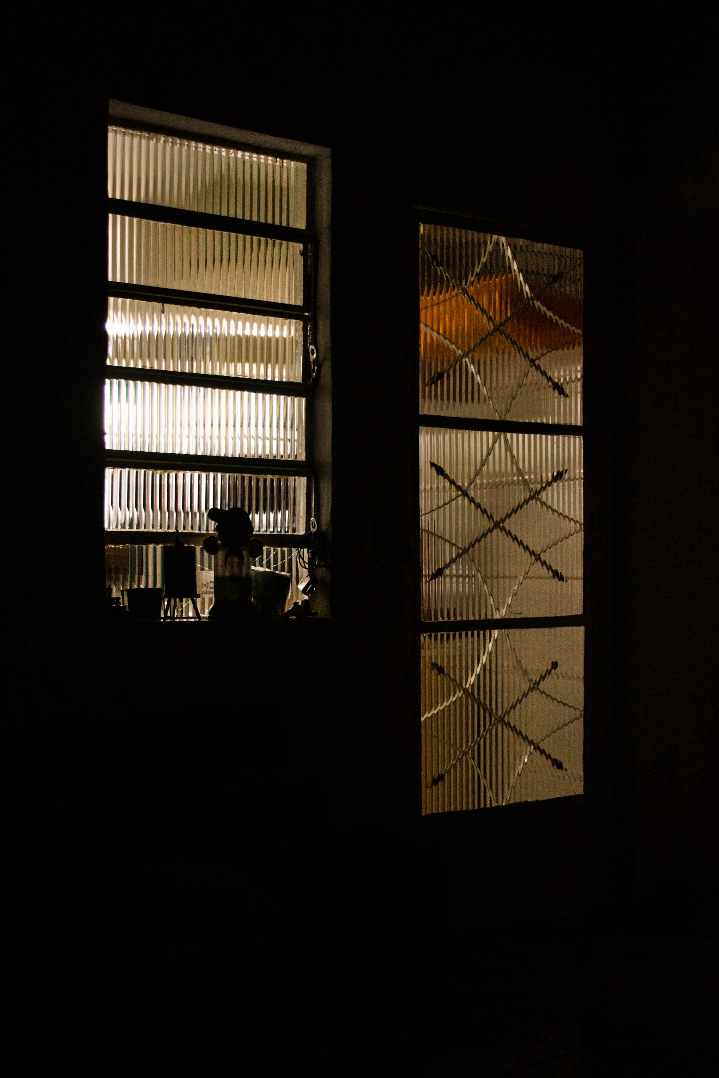 Janela de vidro fosco com objetos silenciosos ao fundo e luz suave entrando no ambiente