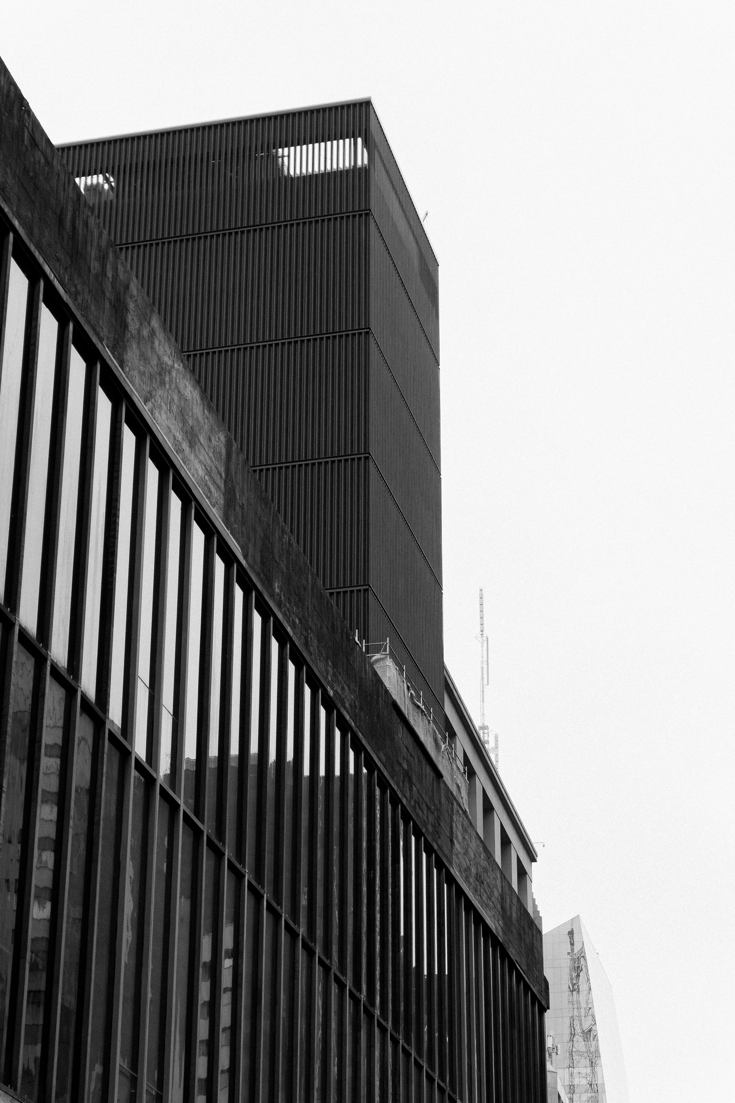 Construções de edifícios com fachadas de vidro e uma estrutura de ferro, em uma cidade moderna, vista de baixo para cima.