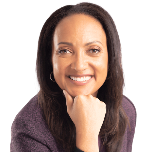 A woman with long dark hair, wearing a purple blazer, smiling with her hand resting on her chin.