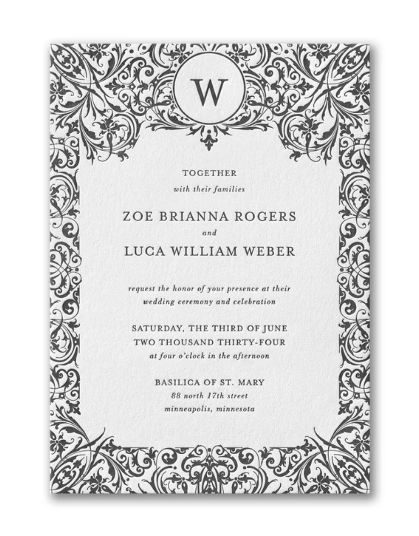 Wedding invitation with ornate black and white floral border, featuring a monogram 'W' at the top, and details of the wedding ceremony in the center.