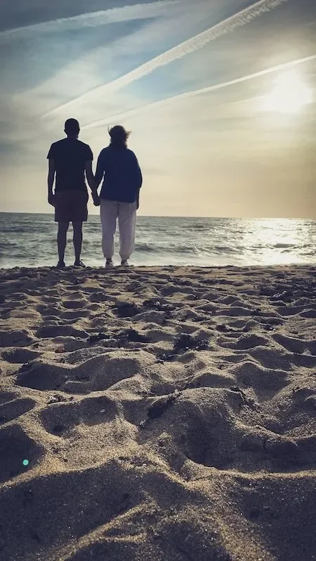 A man and woman at sunset on the beach holding hands