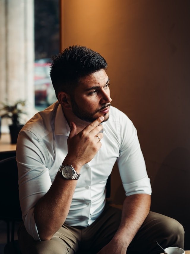 a man thinking in a white shirt