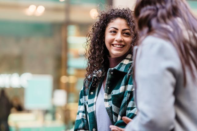 a woman walking with her friend and smiling