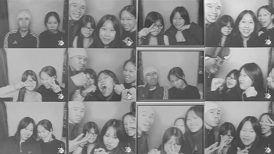 Group photo of multiple people making funny faces and posing for a photo in a photo booth.