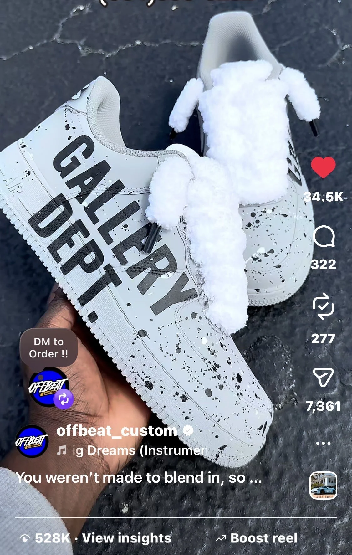 White sneaker with black paint splatter design and the words "GALLERY DROP" printed on the side, held in a person's hand, with snow on the ground and in the sneaker.