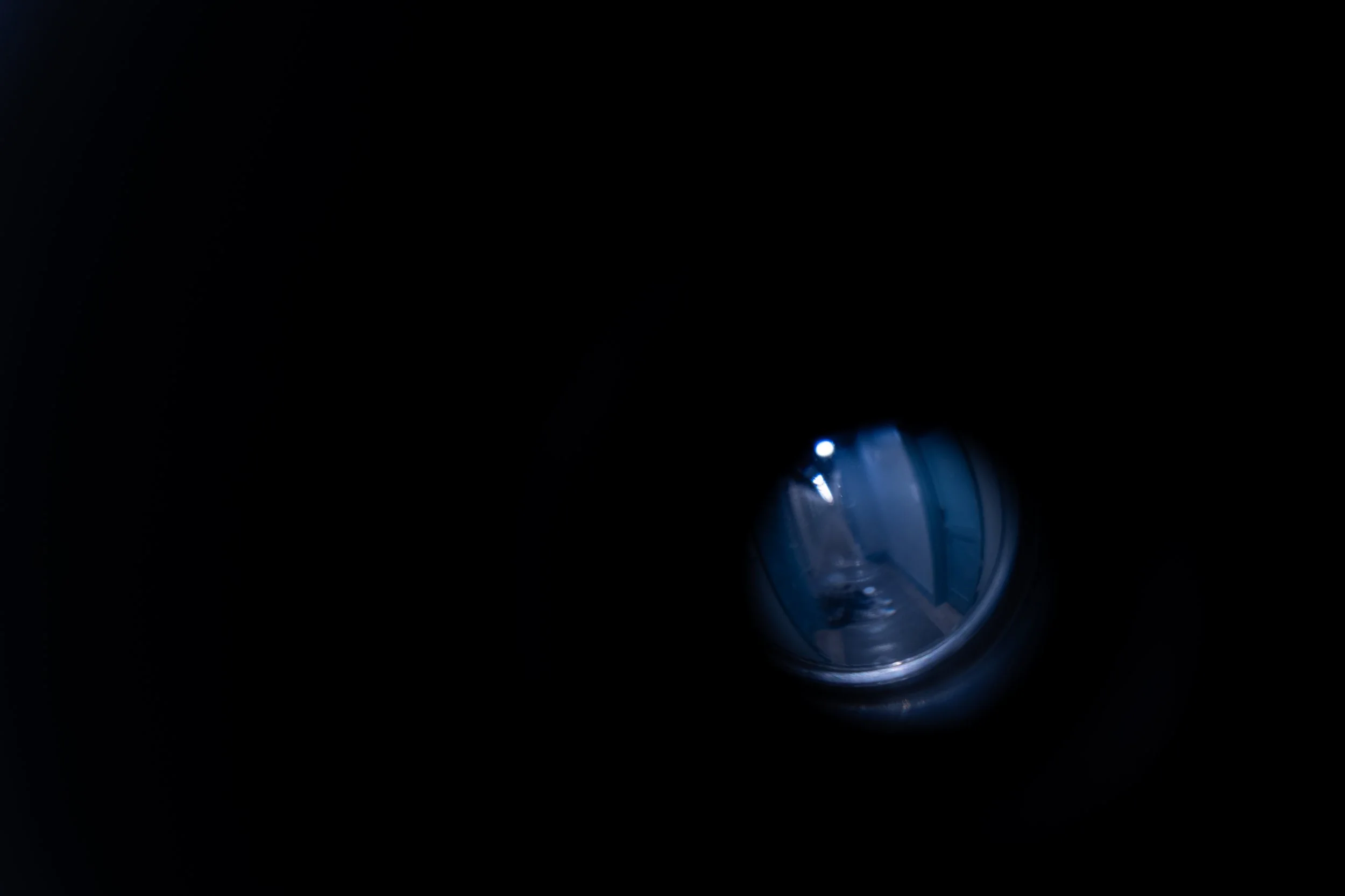 A washing machine door with a view inside, showing the drum and blue lighting.