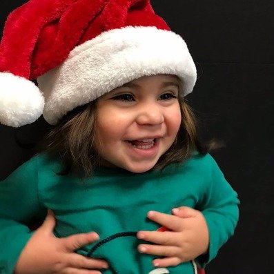 Kendall Bug wearing a Santa hat and smiling happily.