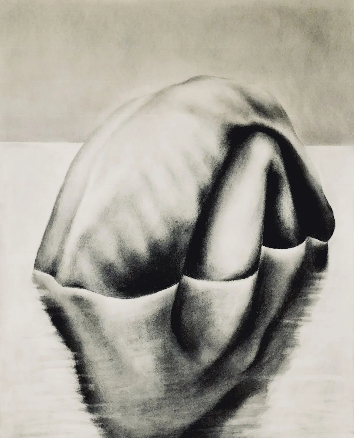 Charcoal on paper,

 24 × 18 inches.

This drawing presents a folded human form seated in shallow water, reducing the body to its essential curves and shadows. With the head and limbs obscured, the figure is defined by weight, contour, and the quiet 