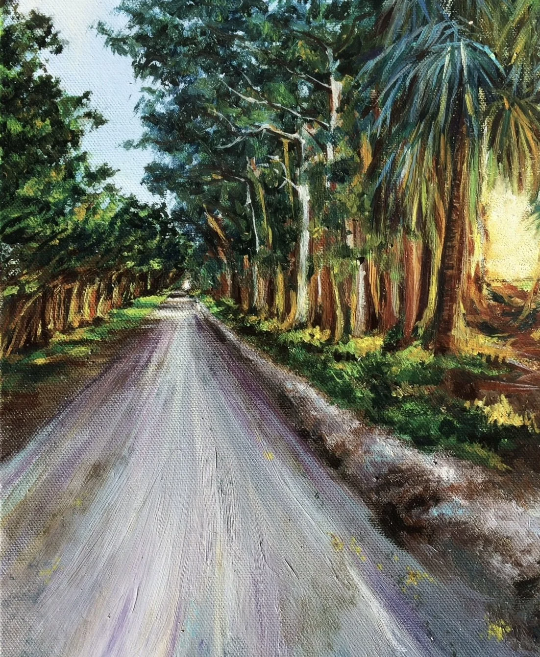 A dirt road runs through the center of this landscape, flanked by green trees with dense foliage on both sides. The sky is visible at the top, and sunlight filters through the trees on the right, creating a bright glow.