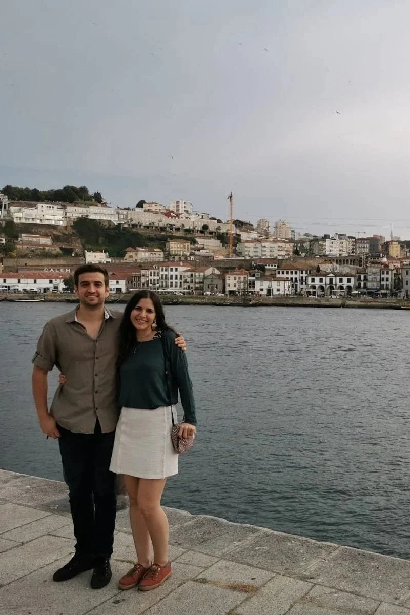 Mariana y Carmen, clientas de Laurie, tomándose las manos sobre un césped verde el día de su boda.