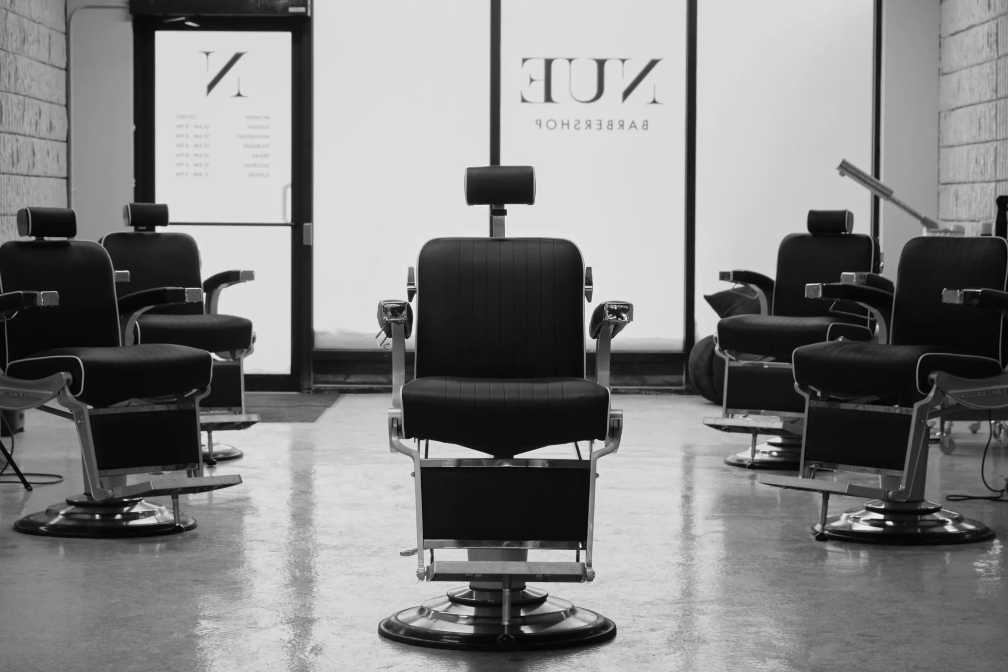 A central barber chair in a luxury Winnipeg barbershop, with matching barber chairs arranged on both sides.