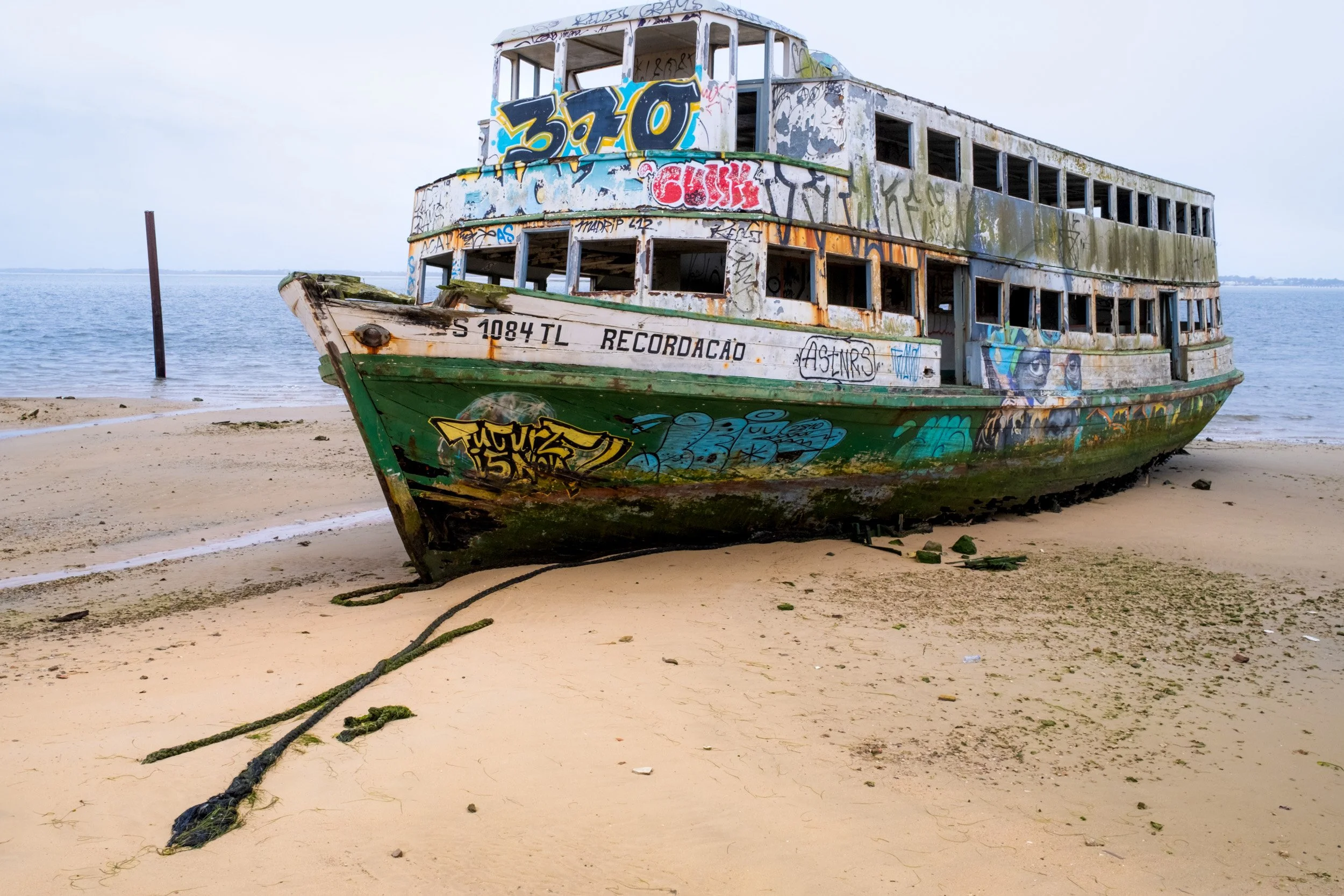 Along the road to the shipyard just outside Setúbal (Portugal), there is a site where I’ve come across various derelict boats over the past 25 years. A graffiti artist has adorned this decaying tour boat with a colourful piece of street art.
Nikon D8