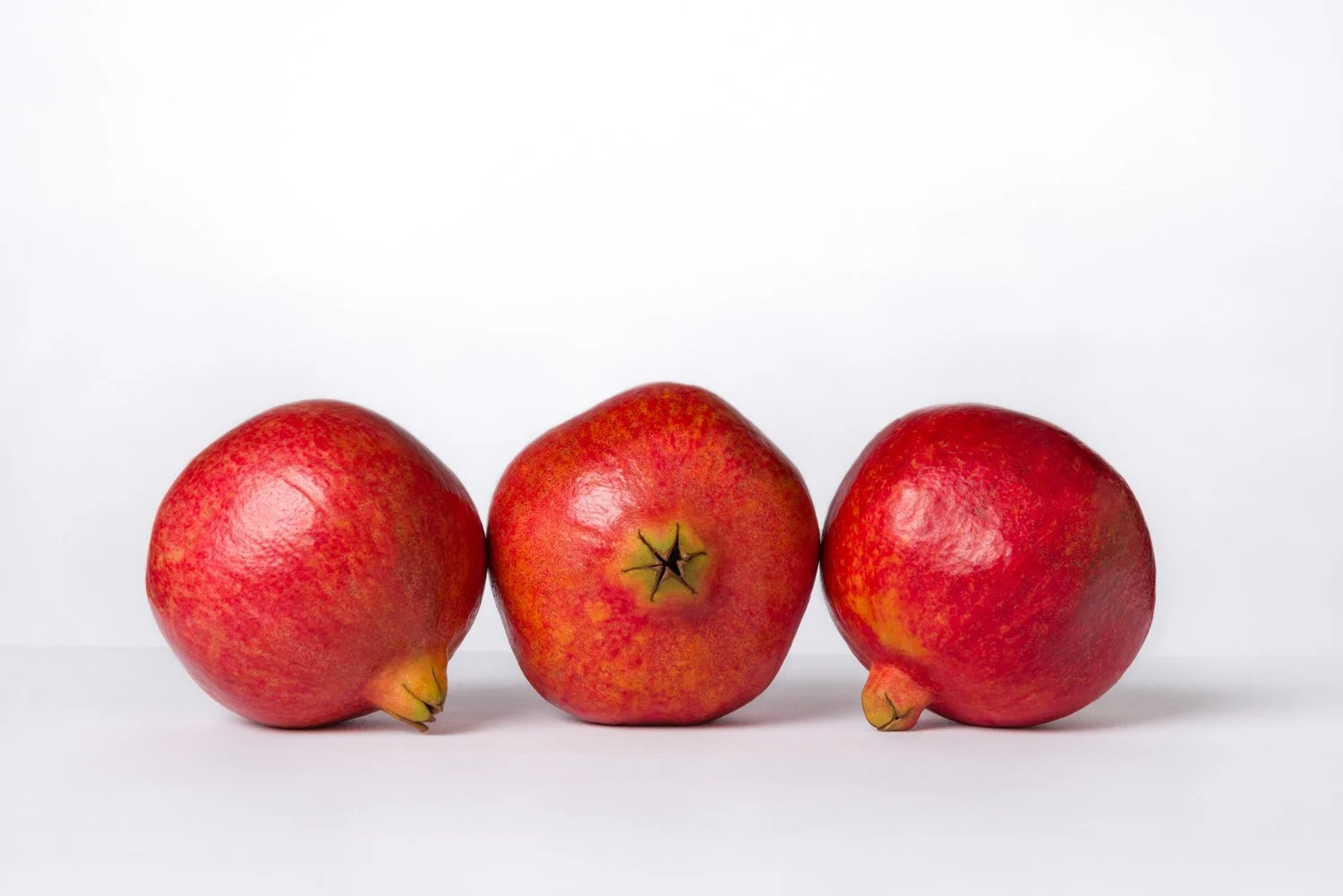 Three red apples on a white background