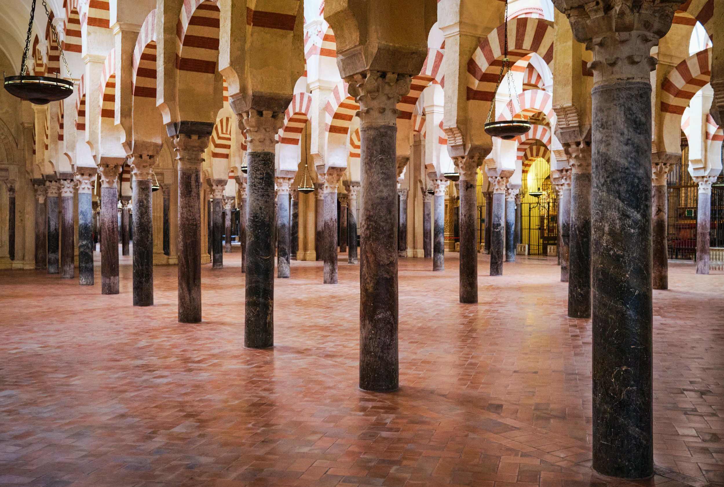 The Horseshoe Arches, Interior of the Great Mosque of Córdoba with rows of marble columns and striped arches in red and white.