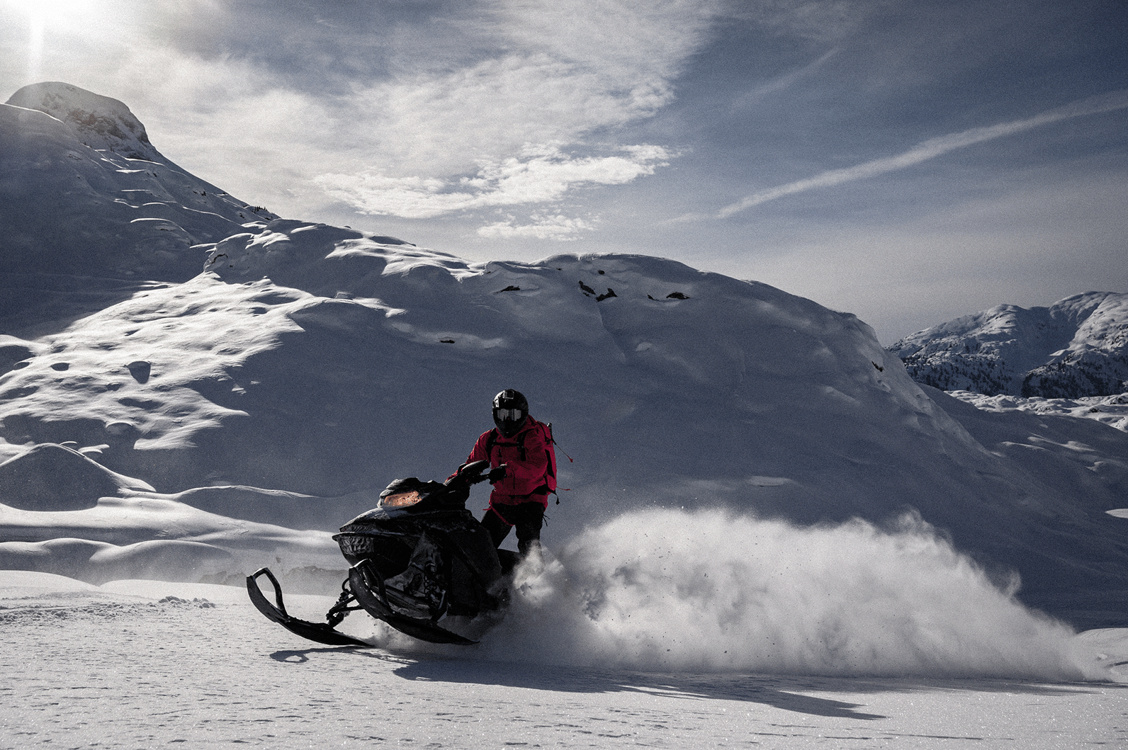 Rider carving through snow on snowmobile built with Dynatool rheocast components.