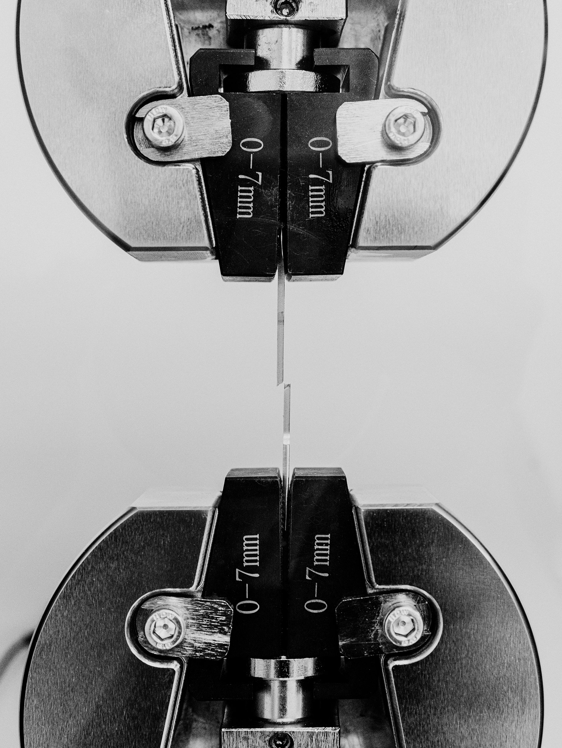 Close-up of a metallic saw blade with cutting depths and measurements in millimeters, viewed from below.