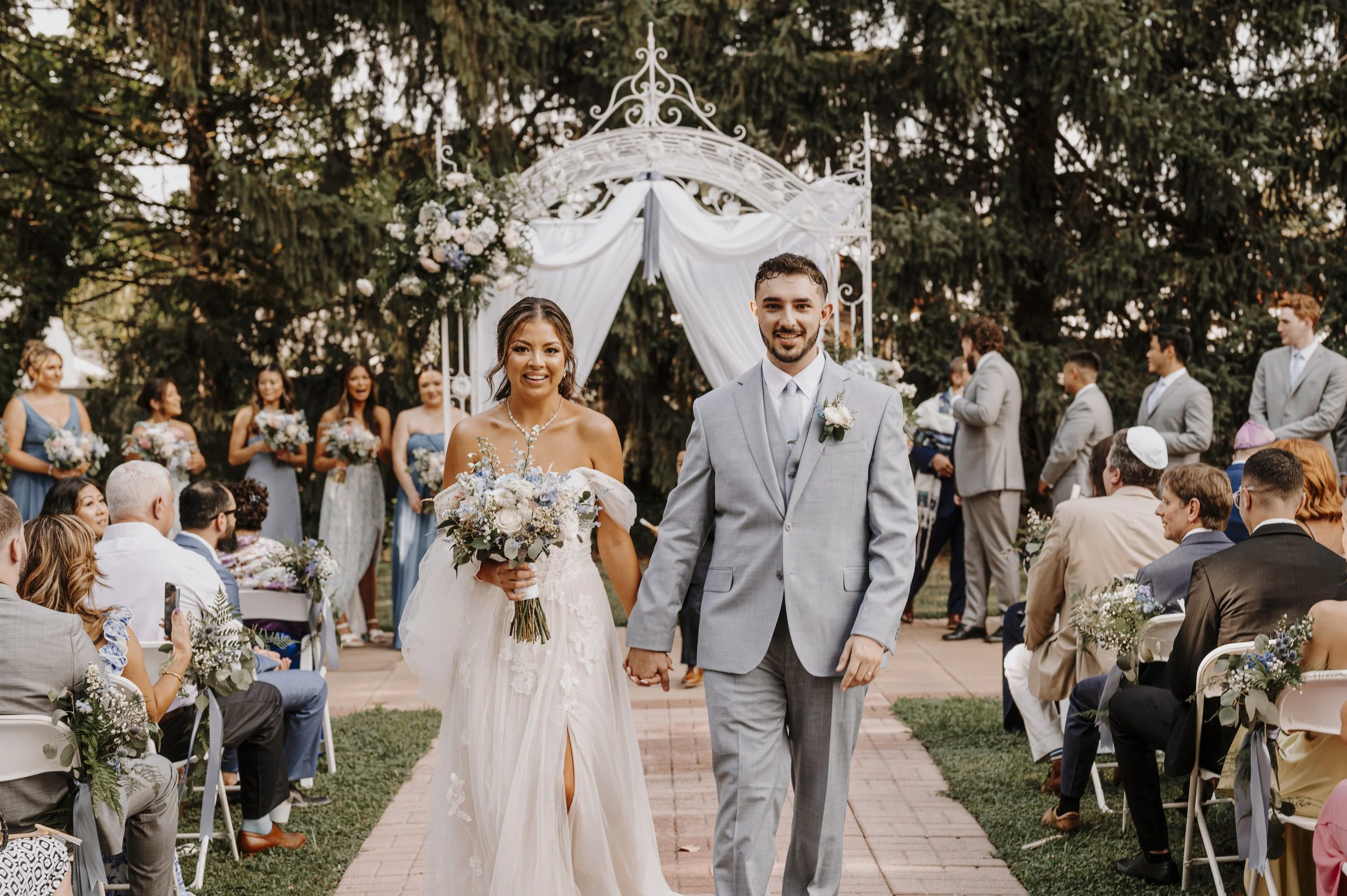 Couple walking down outdoor aisle