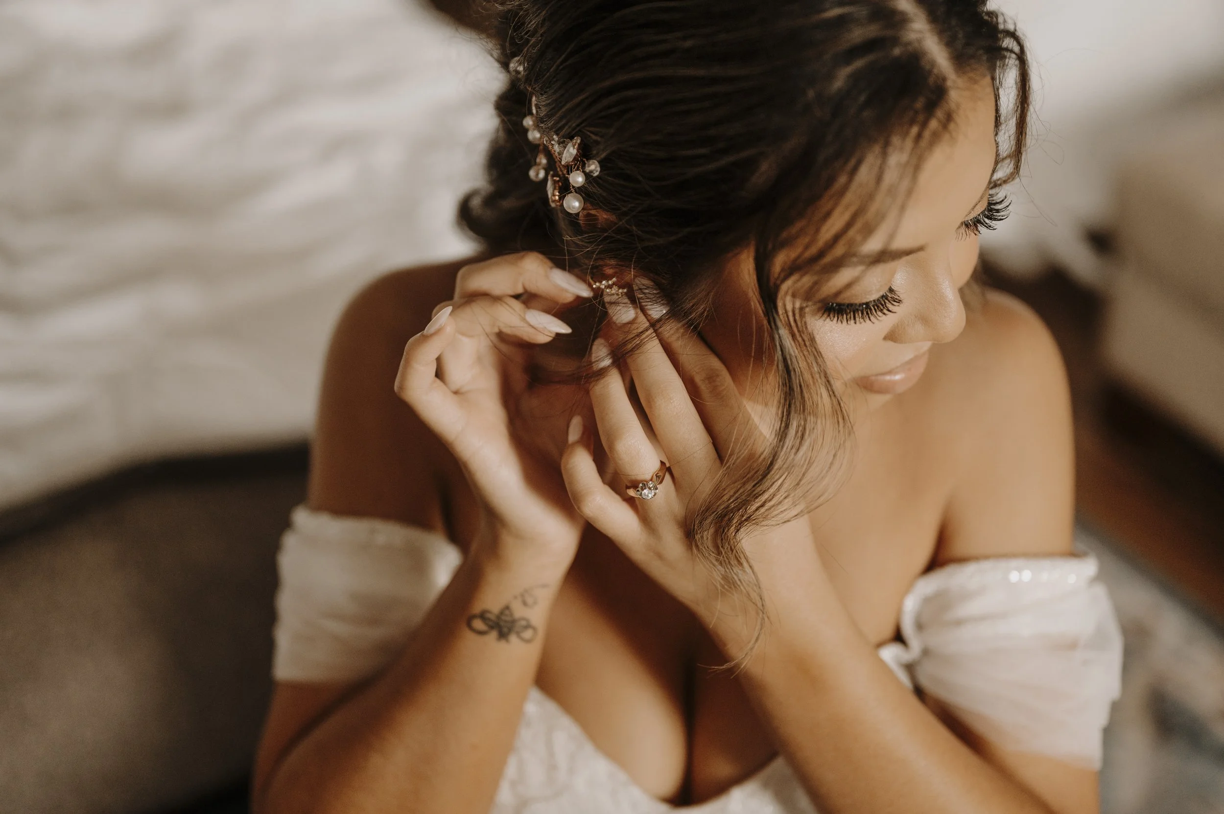 Bride putting on earrings