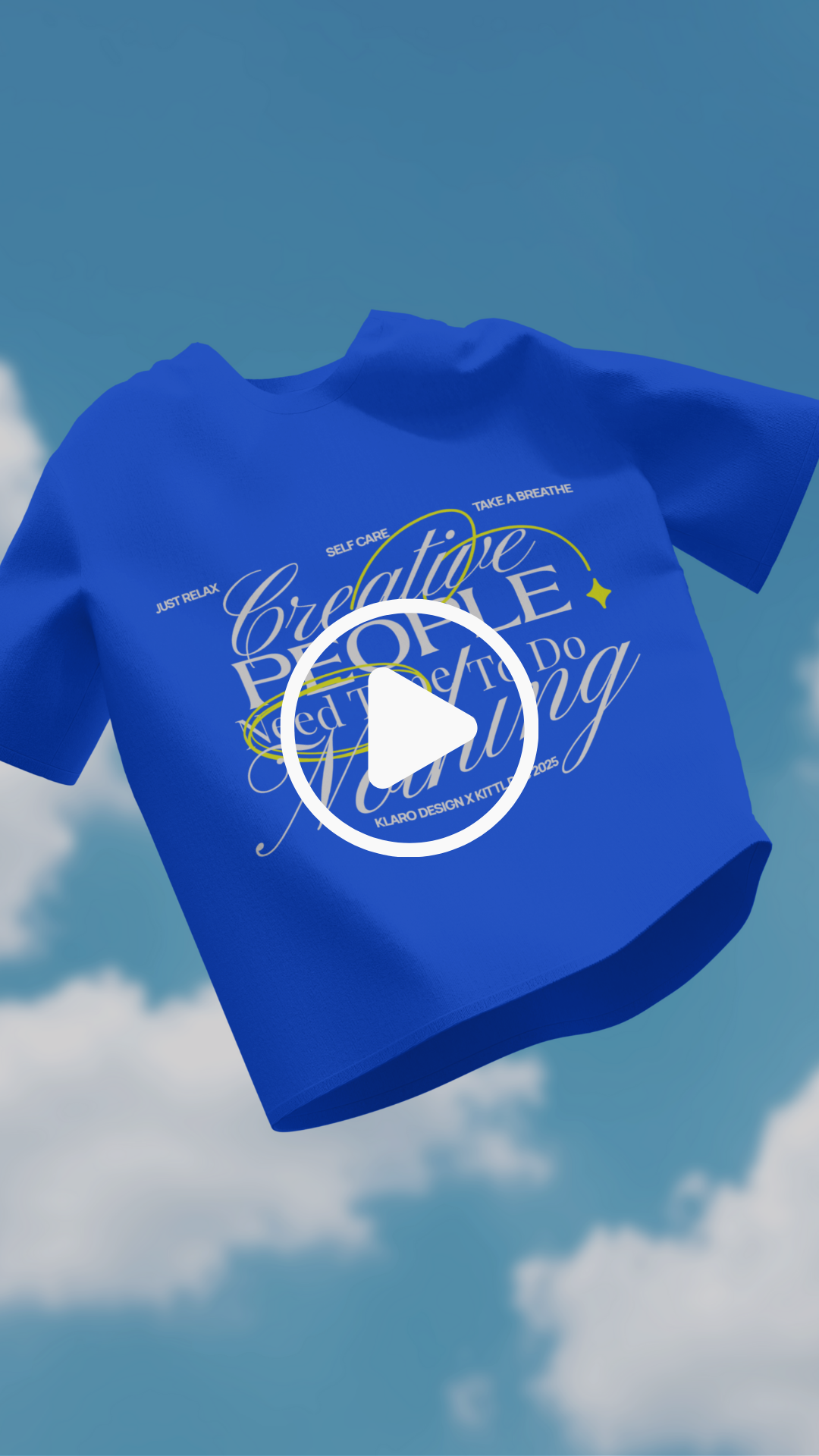 Blue t-shirt with inspirational words such as "Create People," "Do the Thing," and "Just Relax" printed on it, floating in a sky with clouds and a clear blue background.
