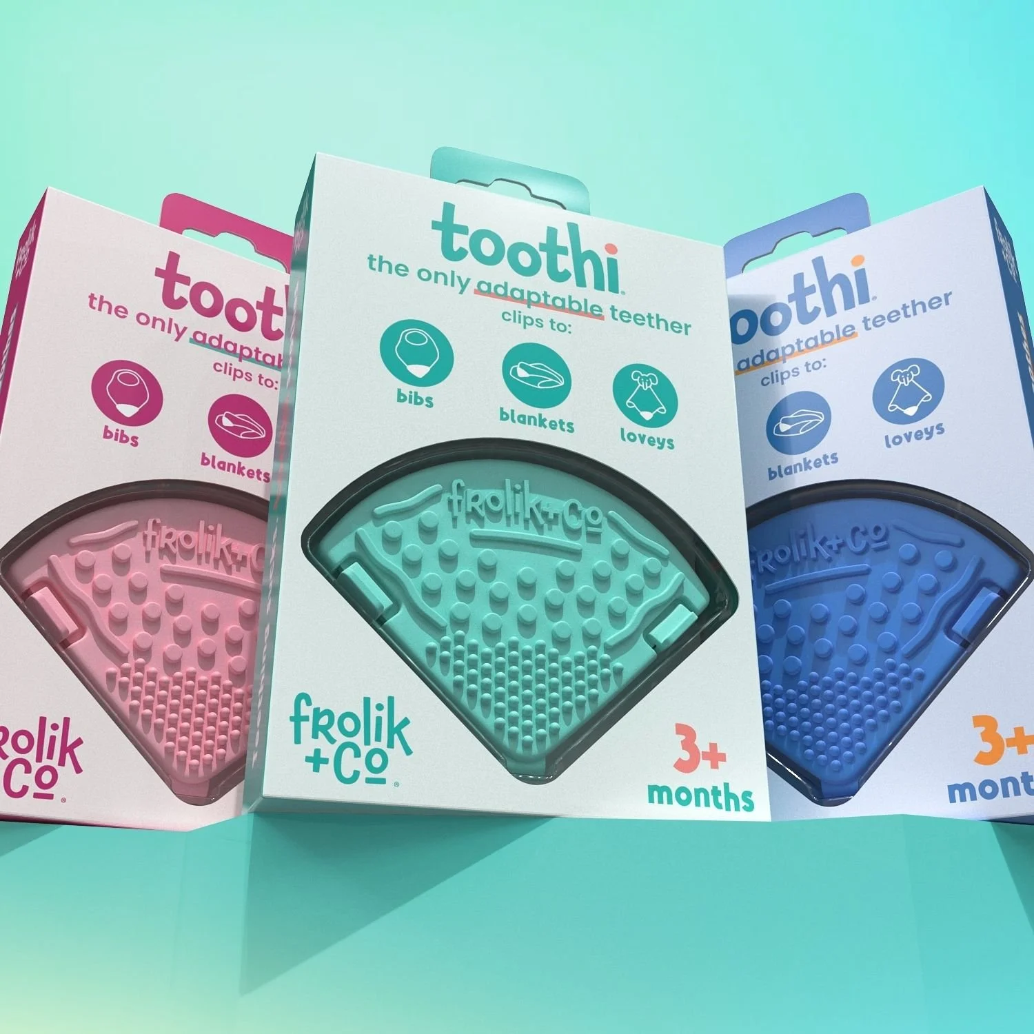 Packaging of Toothi fitting teether in three colors: pink, teal, and blue, designed for children 3 months and older, with clips for bibs, blankets, and loveys.