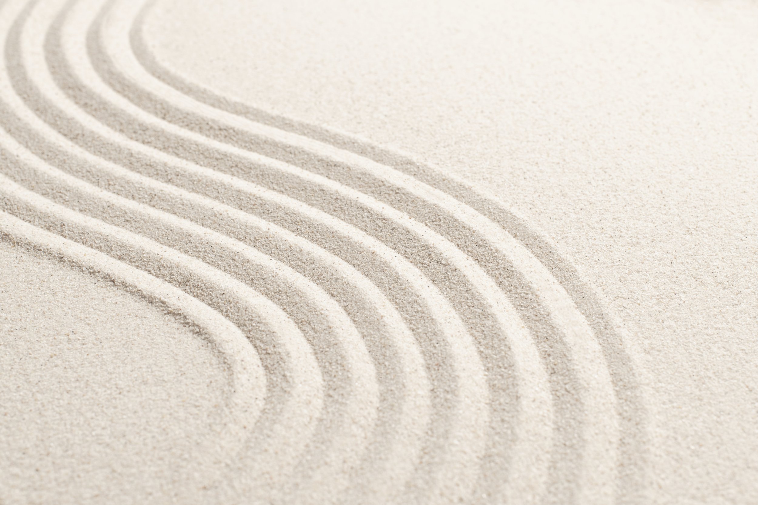 Close-up of ripples in light-colored sand.