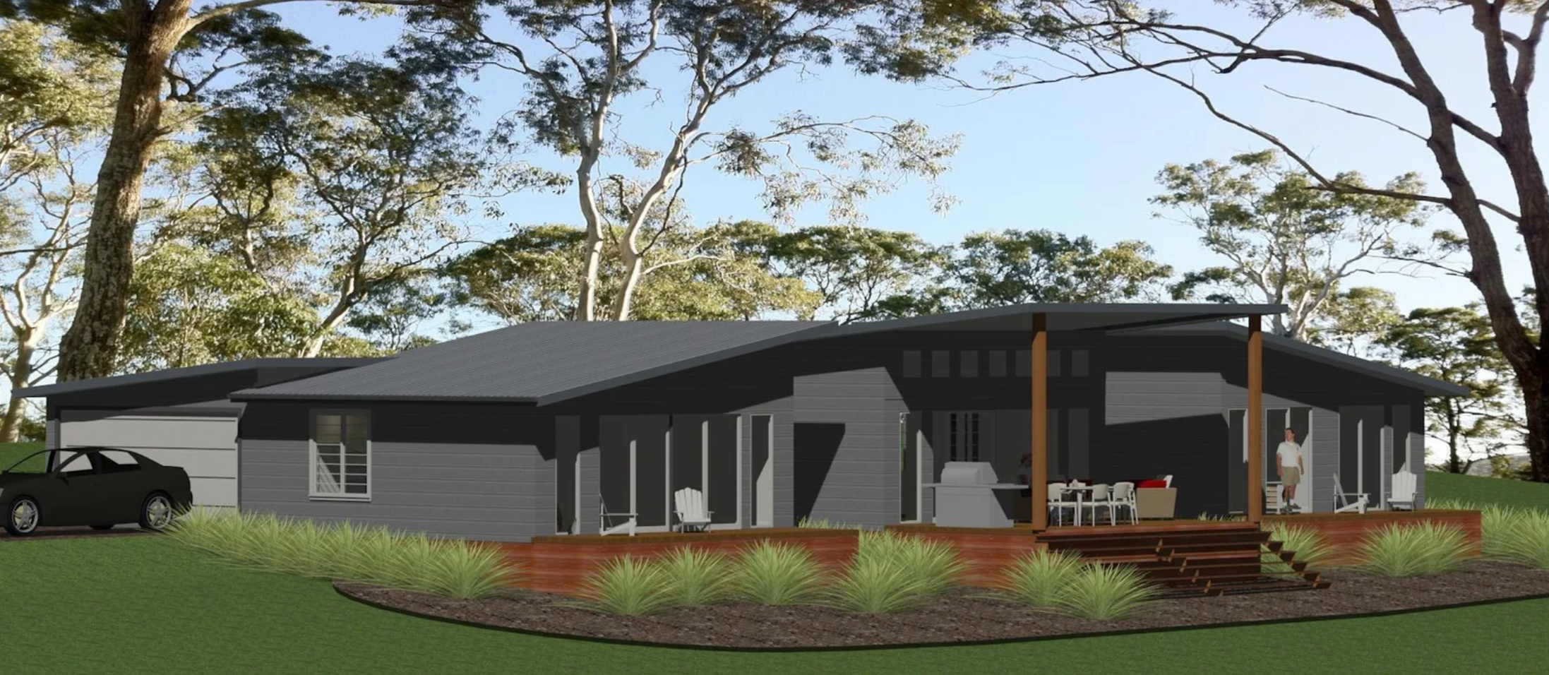 A modern single-story house with a dark exterior, large overhanging roof, and a front porch with seating and a barbecue grill. A person is standing near the house, and a car is parked to the left. The house is surrounded by well-maintained grass and shrubbery, with tall trees in the background.
