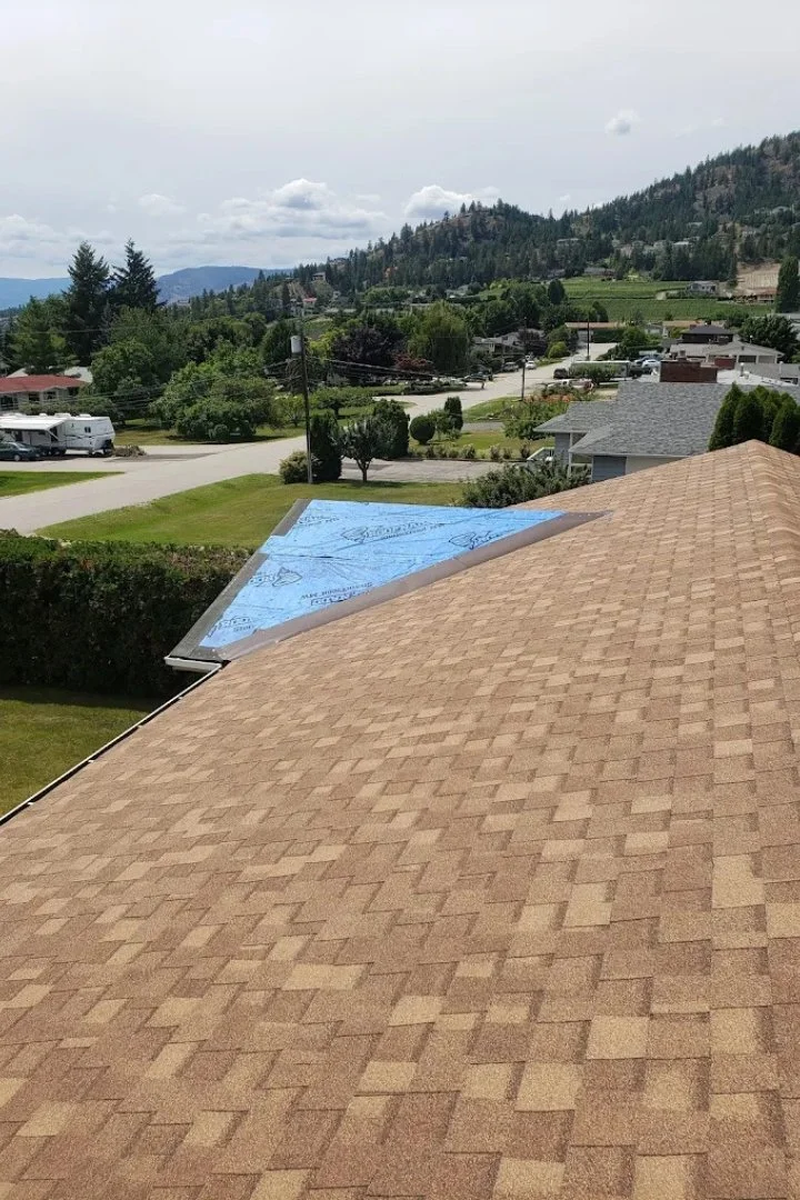 Completed asphalt shingle roof installation on a modern residential home.