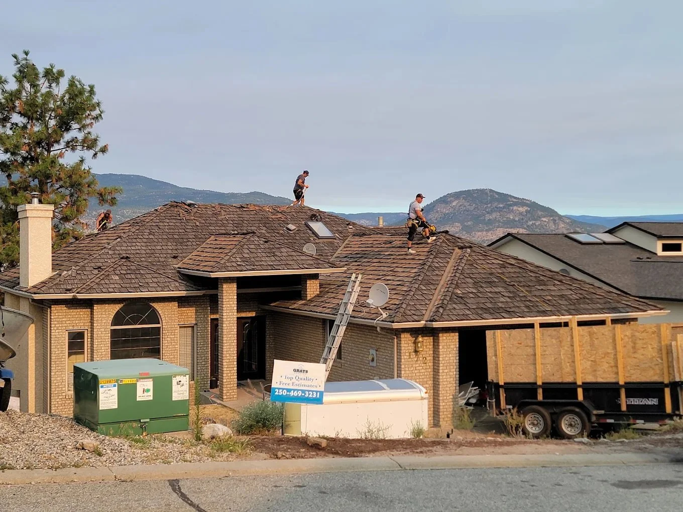 Professional roofing crew installing new asphalt shingles on a residential home.