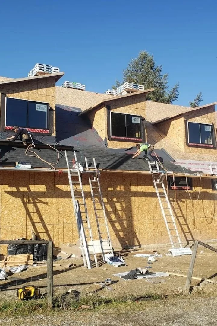 Unfinished roofing project with materials staged and workers preparing the area.