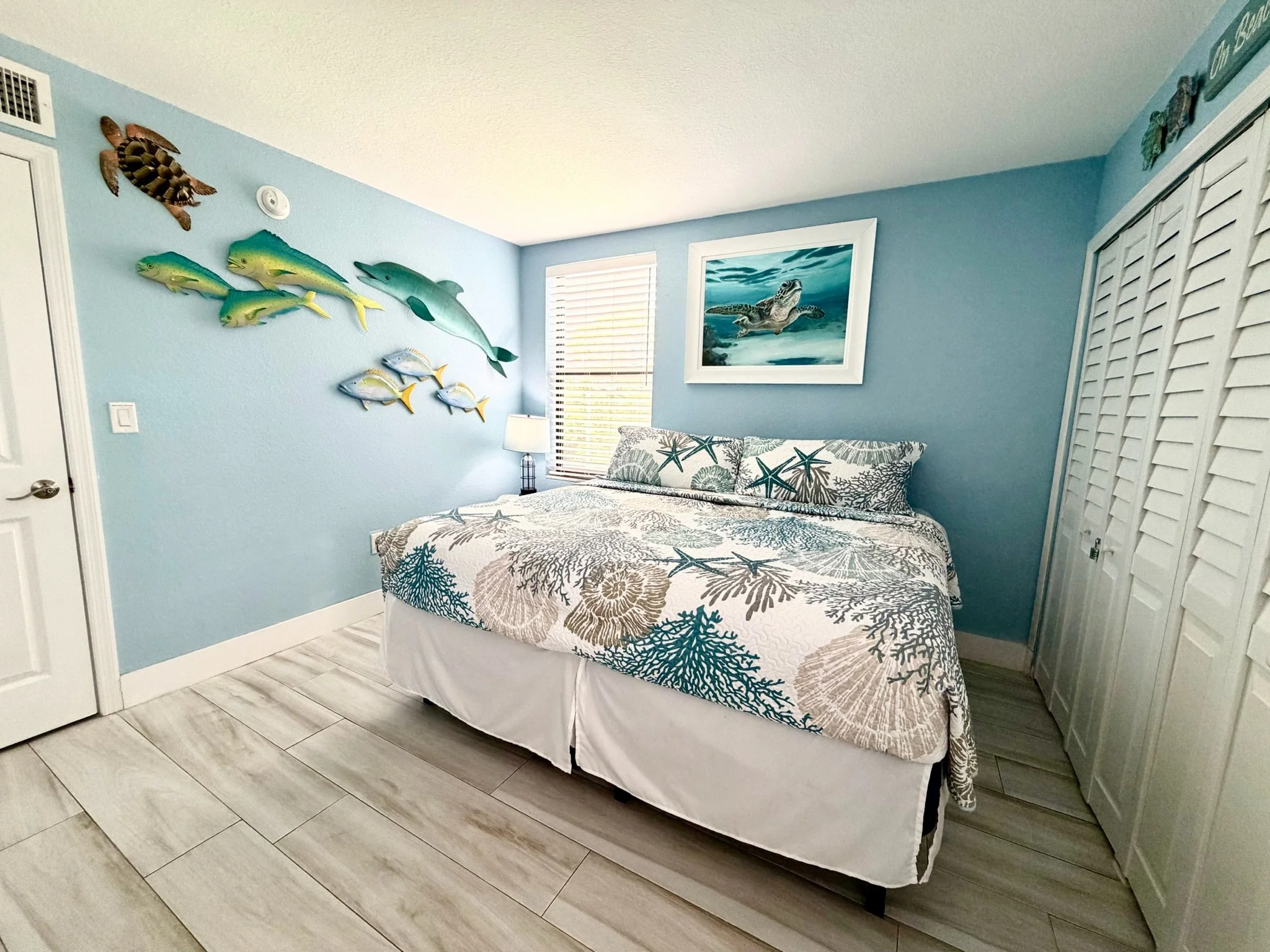 Designed for couples, families, or friends, the guest bedroom at our Moon Bay Key Largo vacation rental offers a king bed or two twin beds upon request, undersea-inspired local artwork, coastal décor, and a Roku TV.