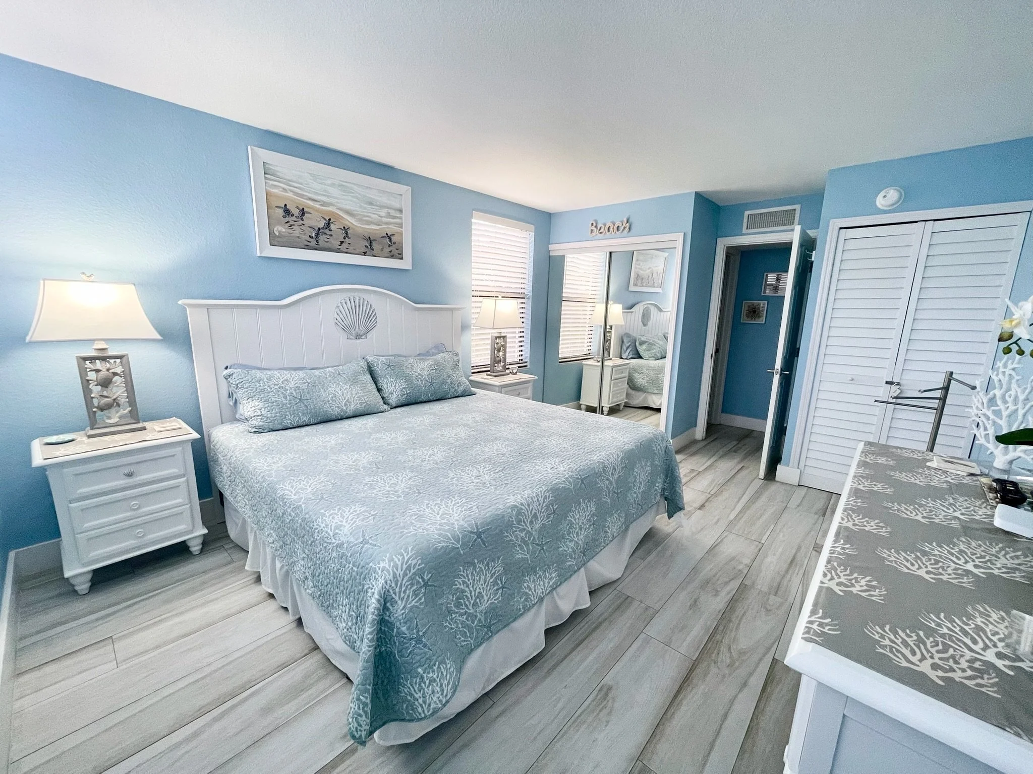 Unwind in the king master bedroom at Sunsets and Turtles, a waterfront vacation rental at Moon Bay in Key Largo featuring coastal décor, sea turtle artwork, coral reef accents, and a Roku TV.