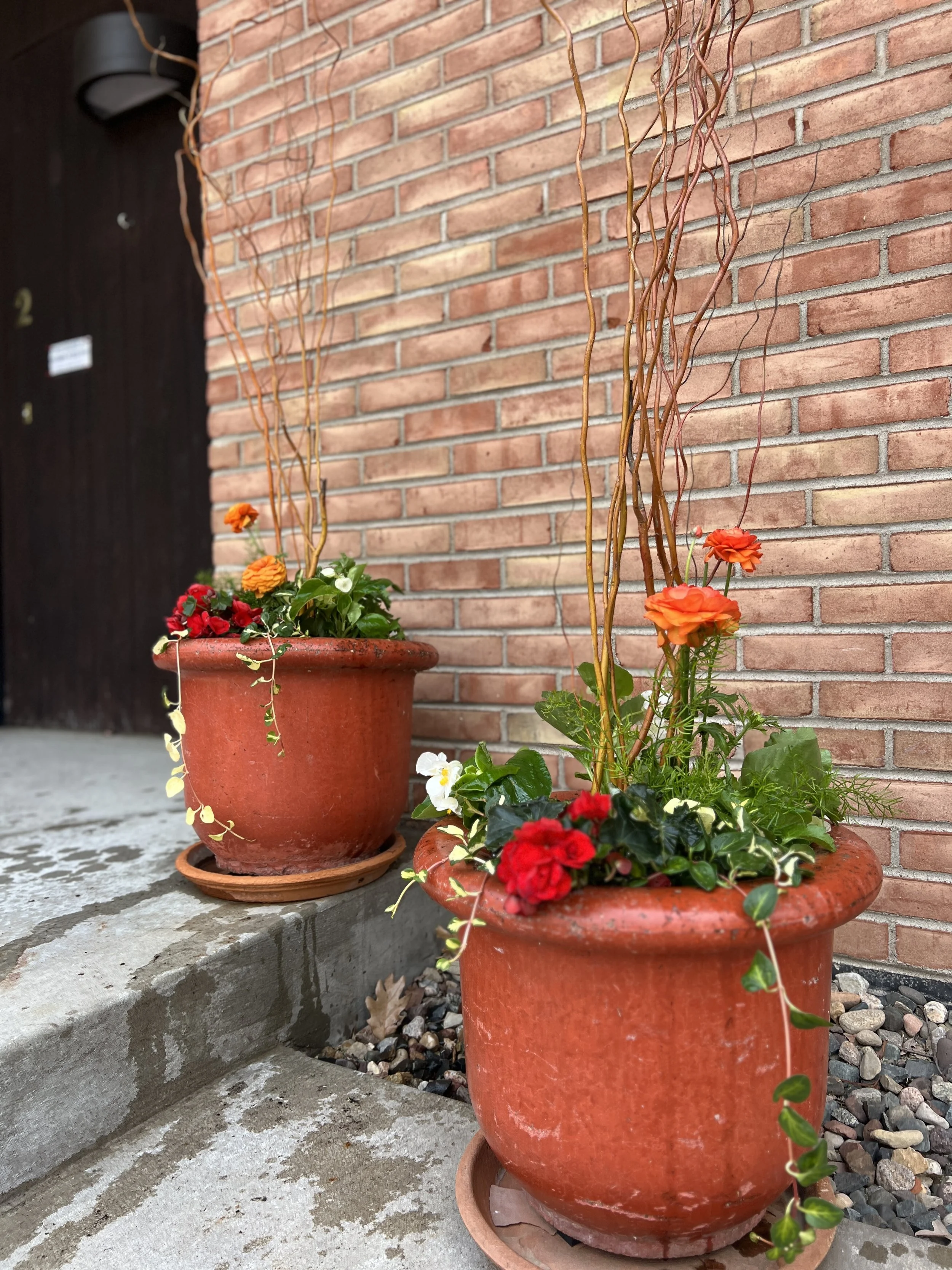 Two spring decorative planters with bright colorful flowers.
