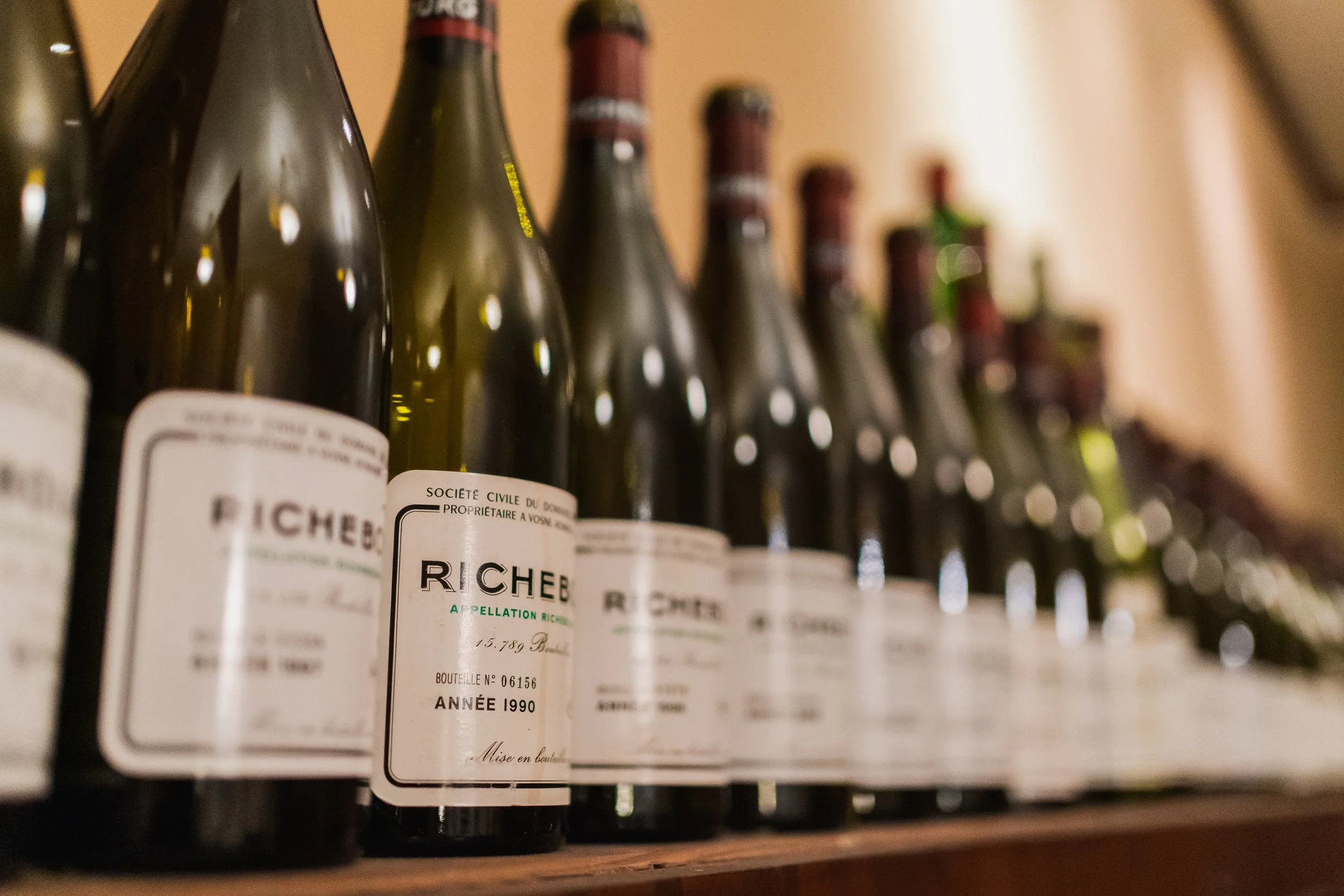 Multiple bottles of Richemont wine with vintage year 1990 on a shelf.