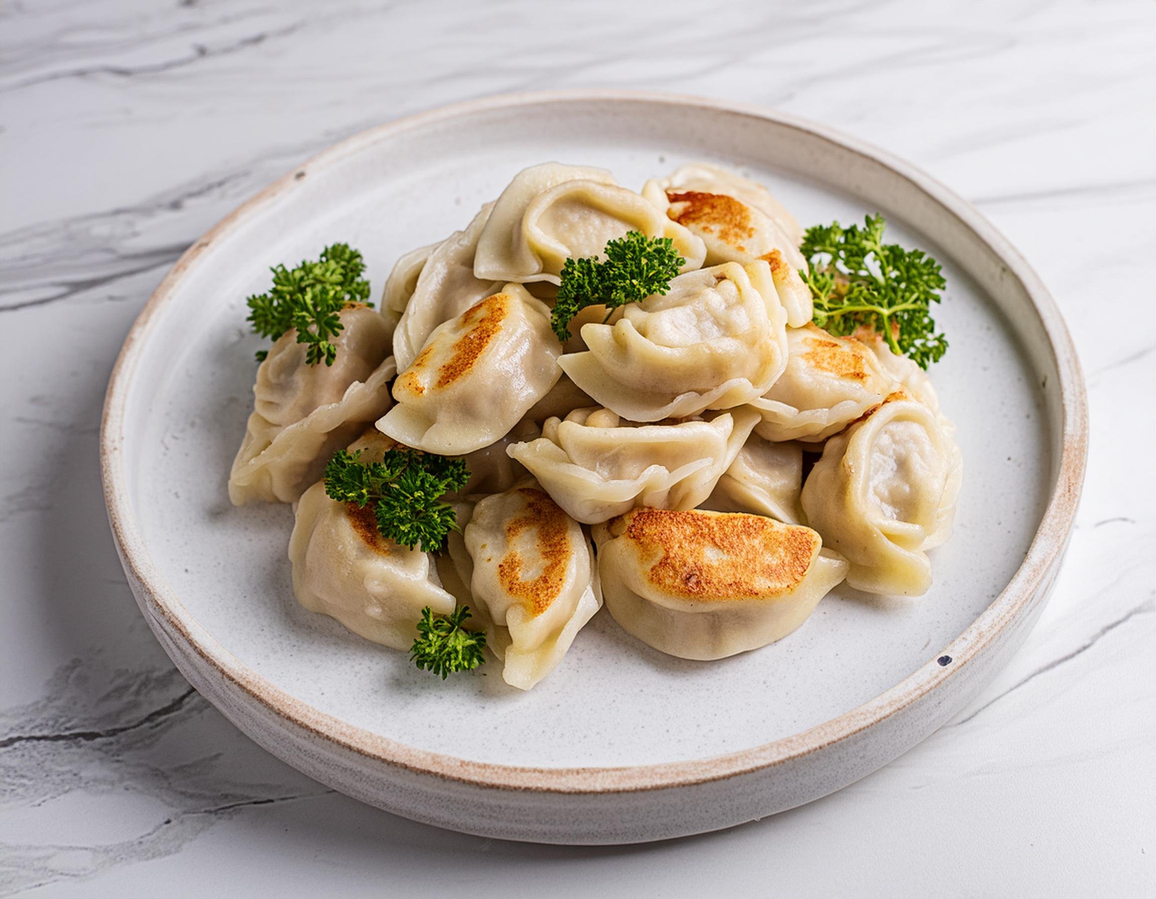 dumplings on a plate with marble Chinese food photography