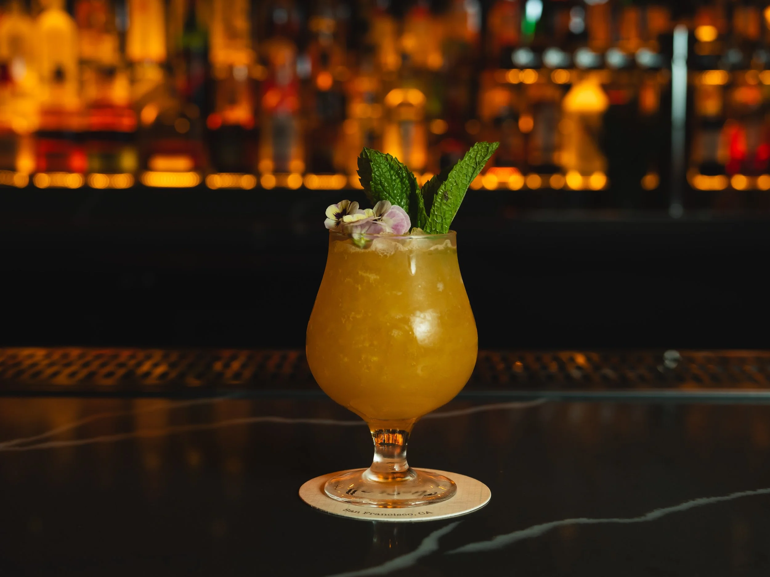 A variety of Italian seafood dishes on white plates, including grilled fish with lemon and mashed potatoes, mussels in pasta, a seafood salad with bread croutons, and a fish fillet with lemon wedges, on a marble table.