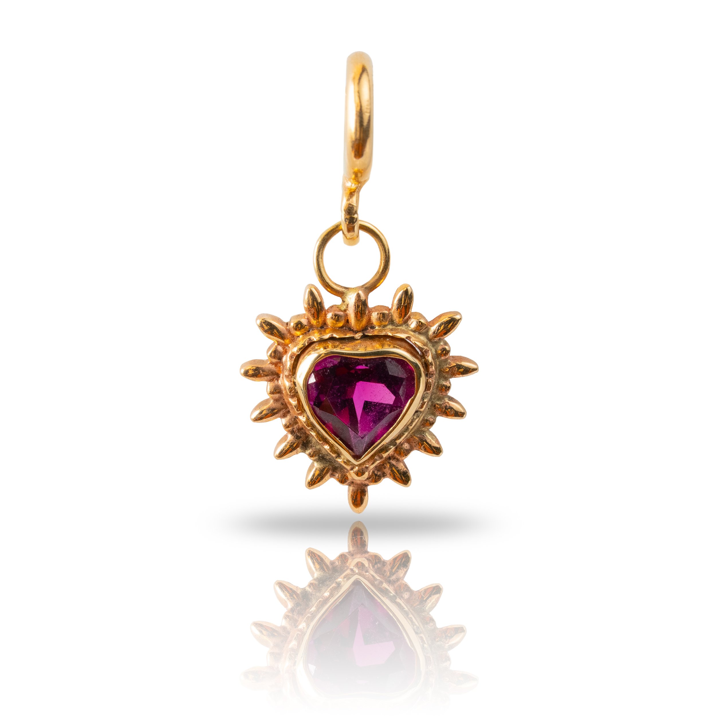 Gold pendant with a heart-shaped purple gemstone surrounded by a sunburst design.