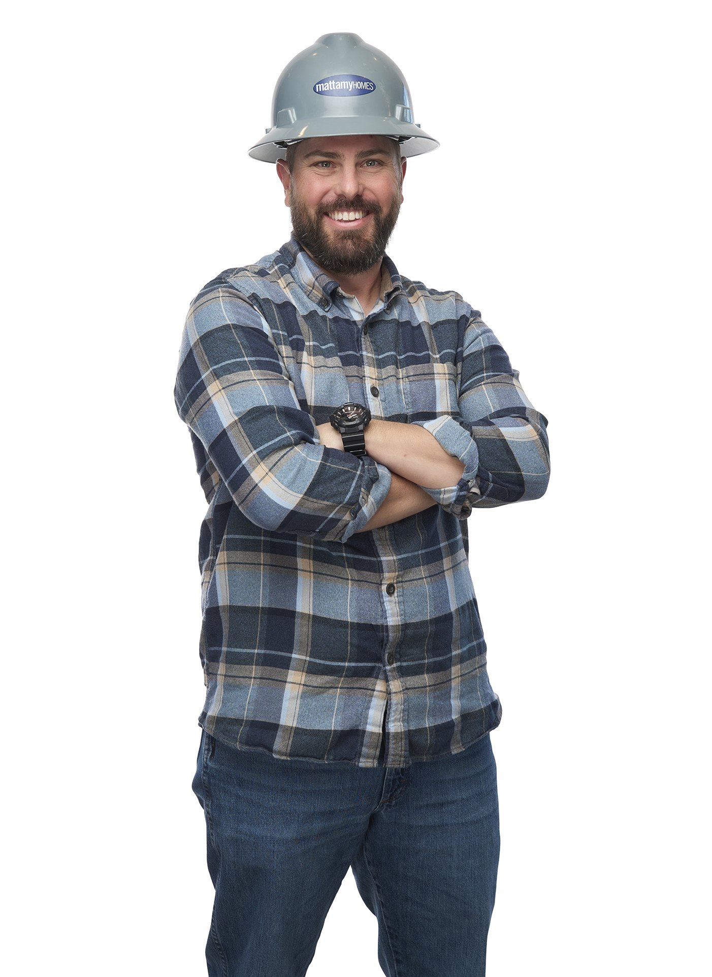 A smiling man wearing a hard hat and plaid shirt with crossed arms against a white background.