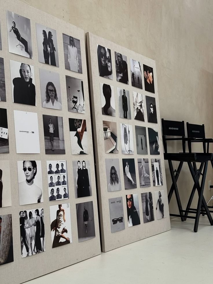 Display boards with black-and-white photos of models, fashion, and accessories, in an indoor setting.