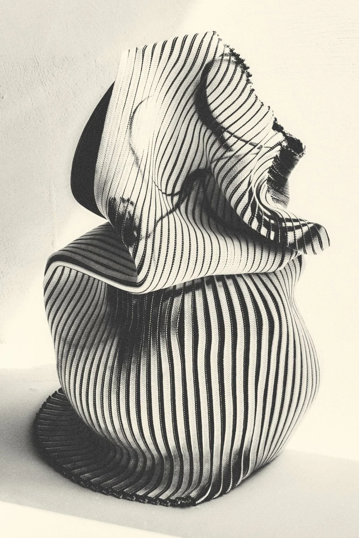 Black and white striped fabric with irregular folds and curves.