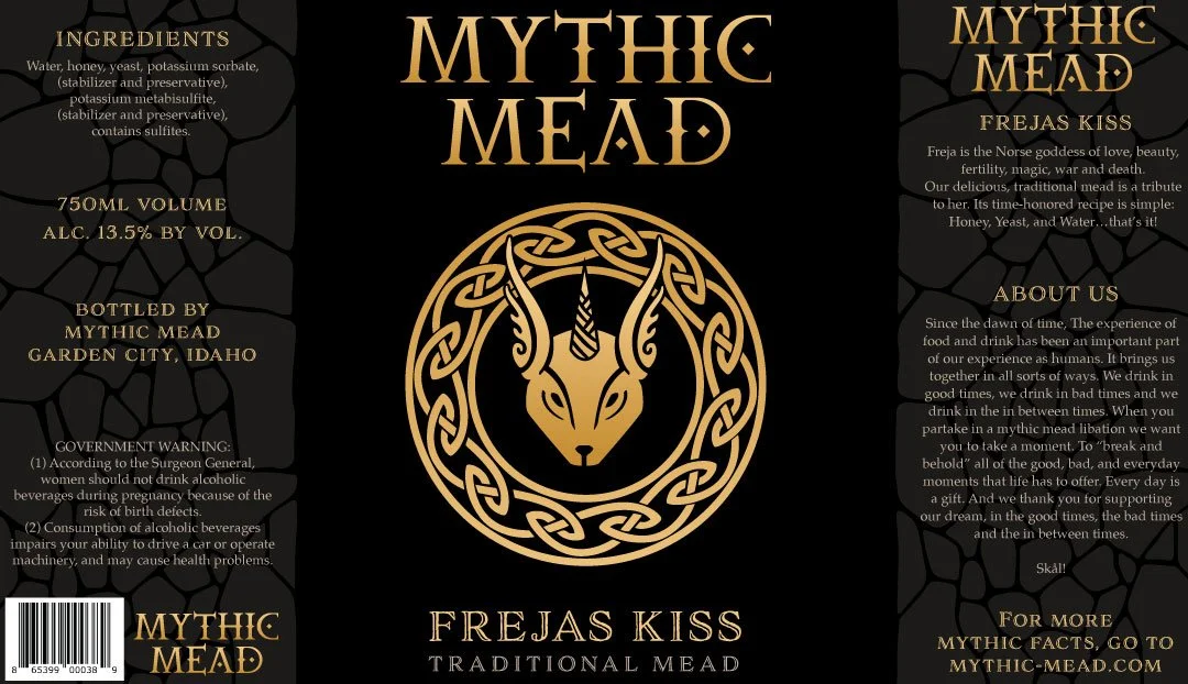 Label for Mythic Mead Frejas Kiss, a traditional mead with honey, yeast, and water, bottled in Garden City, Idaho. Features a Norse goddess Freja and describes the product's mythic and cultural significance.