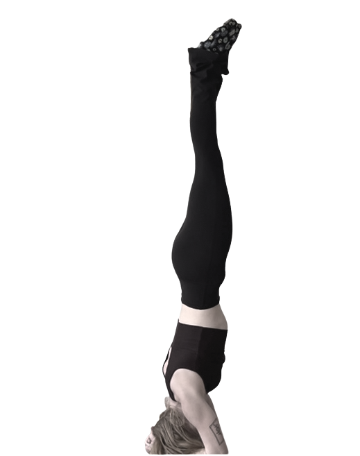 A woman performing a headstand yoga pose against a plain background.