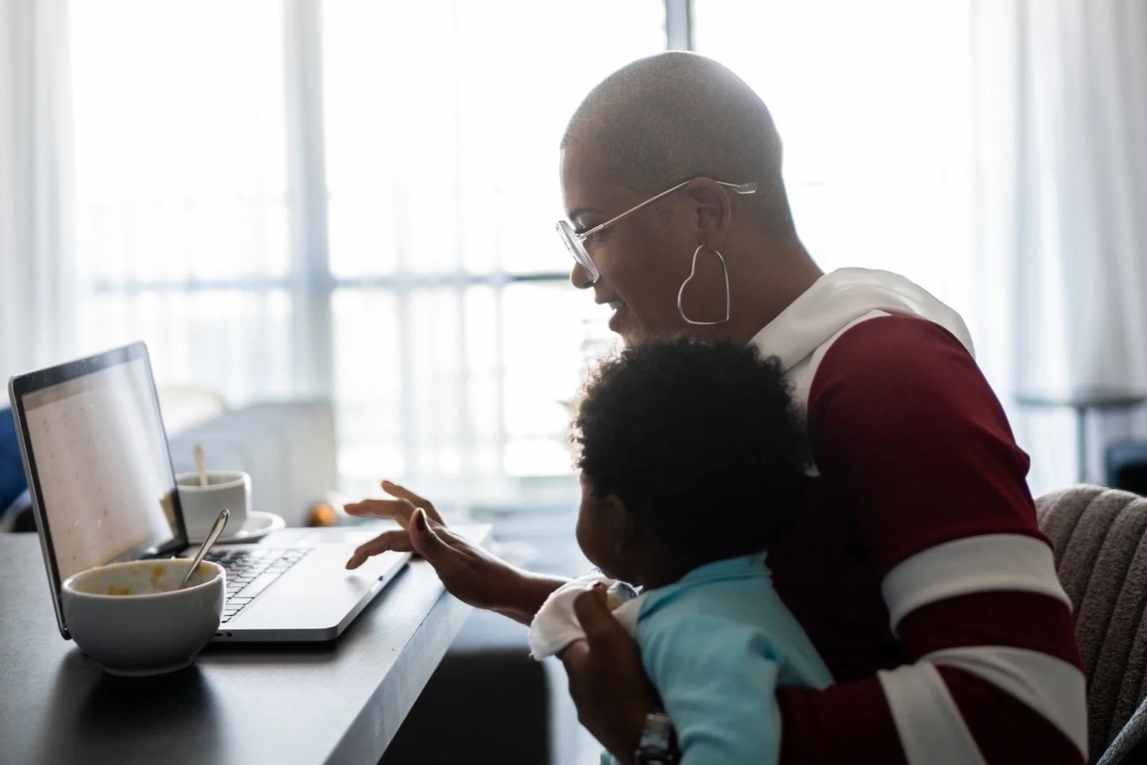 Mother and baby doing taxes on their laptop.