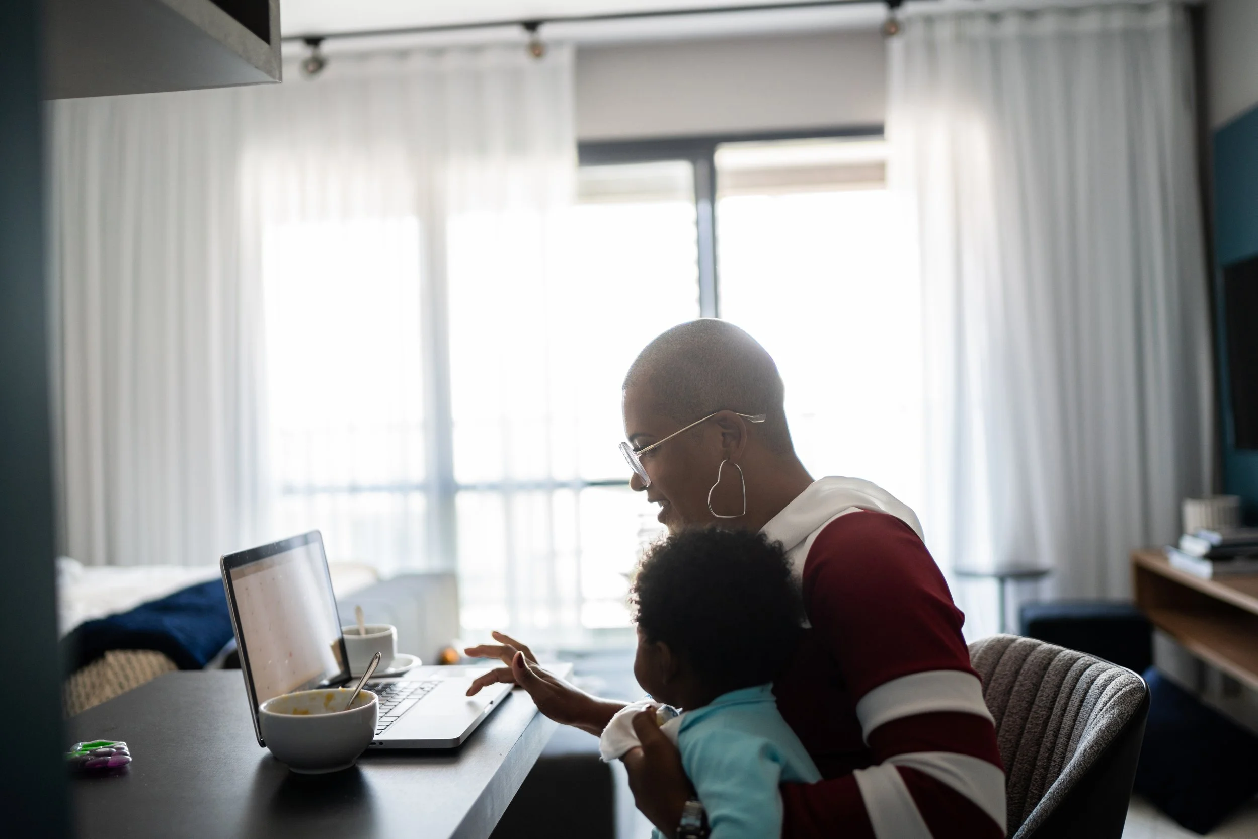 Woman and baby working on laptop.