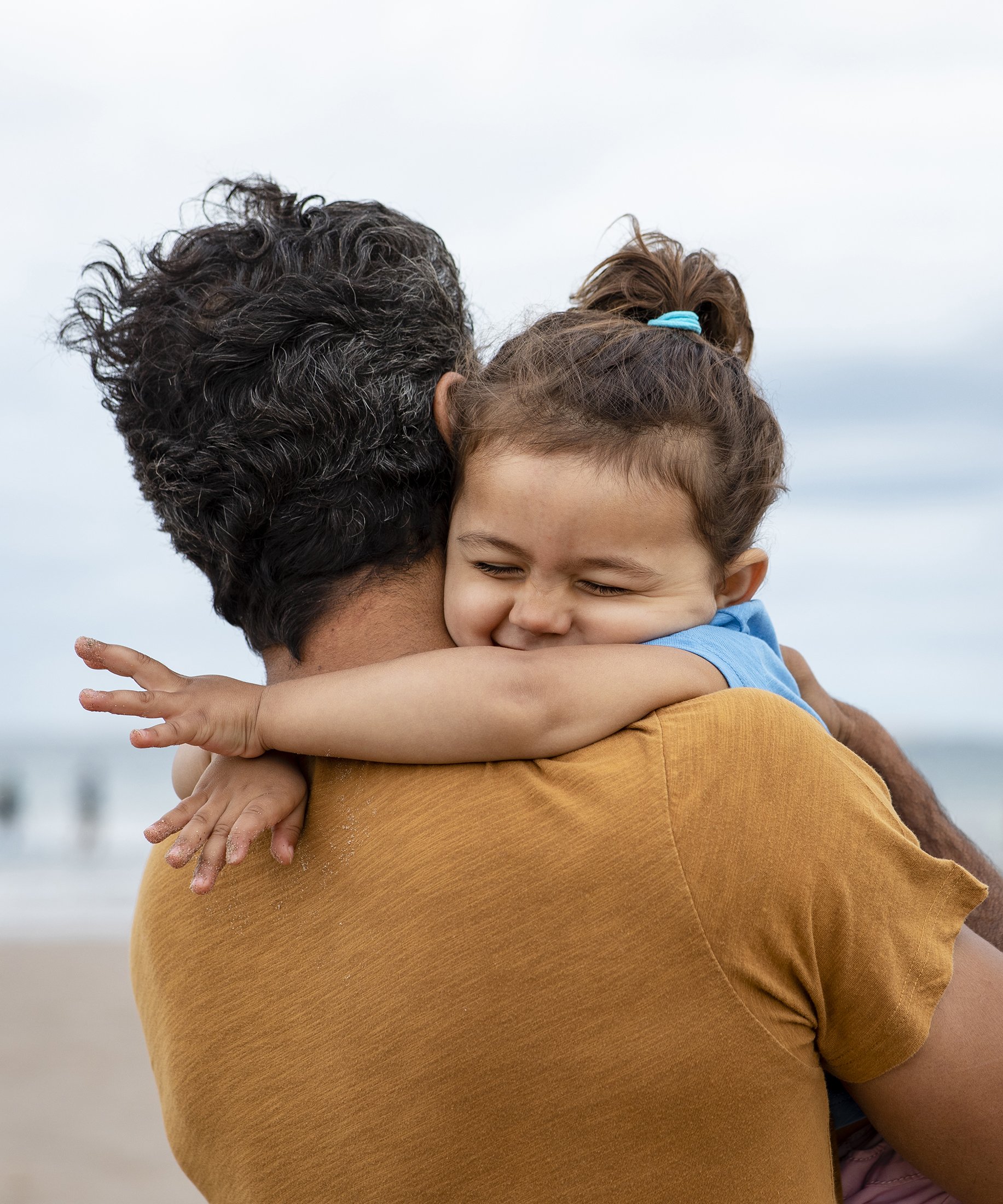 Father and young daughter sharing a hug.