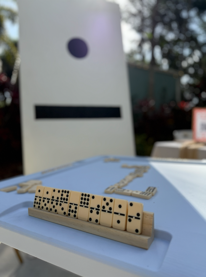 DOmino pieces set up on a wooden stand on top of a white domino table