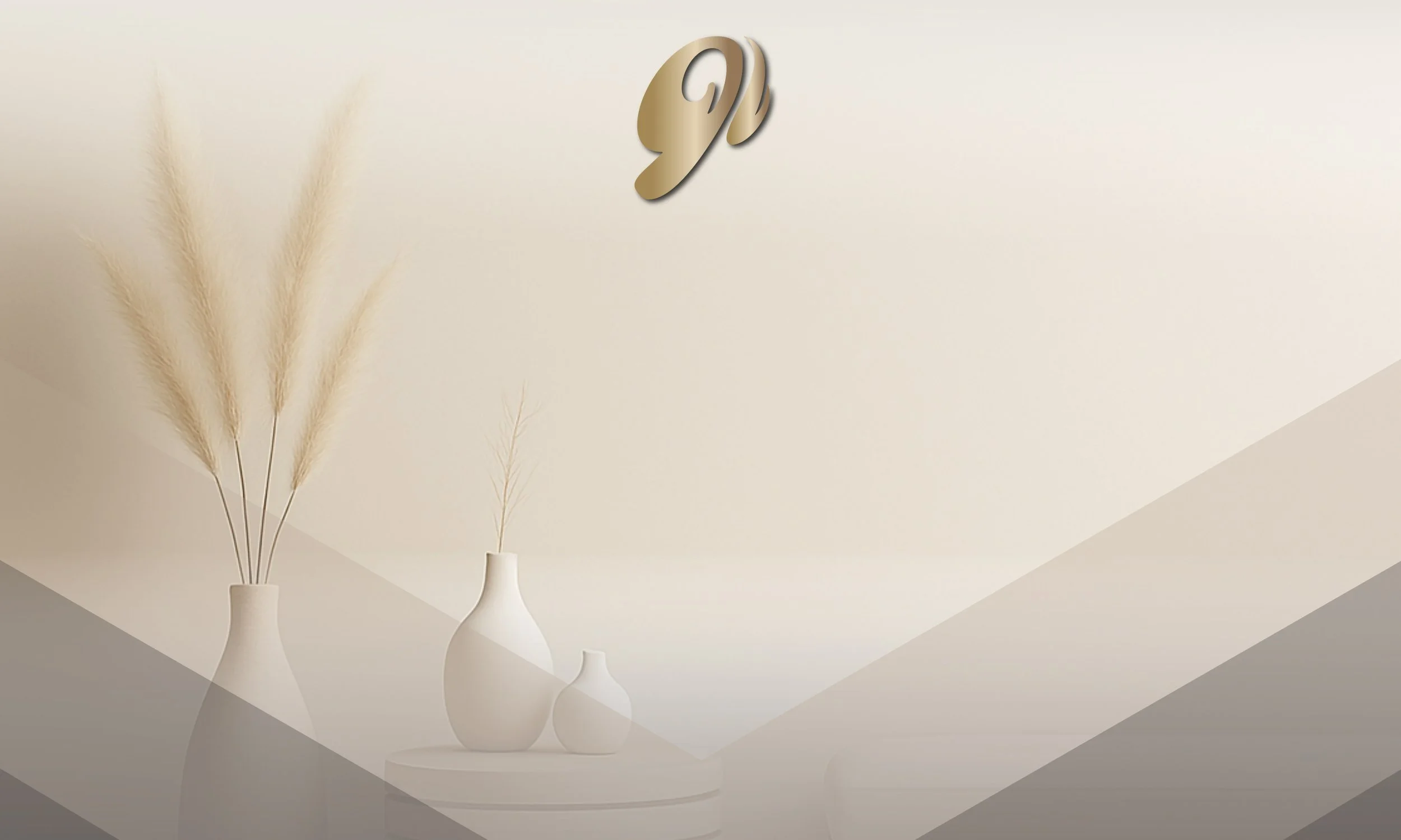 Minimalist interior with three white vases of varying sizes and tall pampas grass on a white surface, with a beige wall in the background and a metallic gold letter 'J' on the wall.